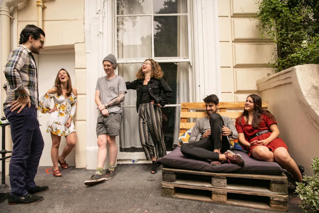 Group of travelers at the terrace of Onefam Notting Hill Hostel in London