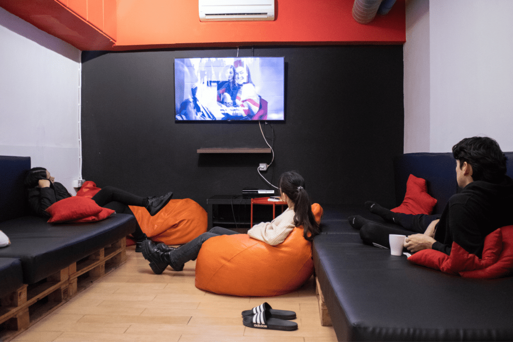Group of travelers in the Netflix room at Onefam Les Corts Hostel in Barcelona