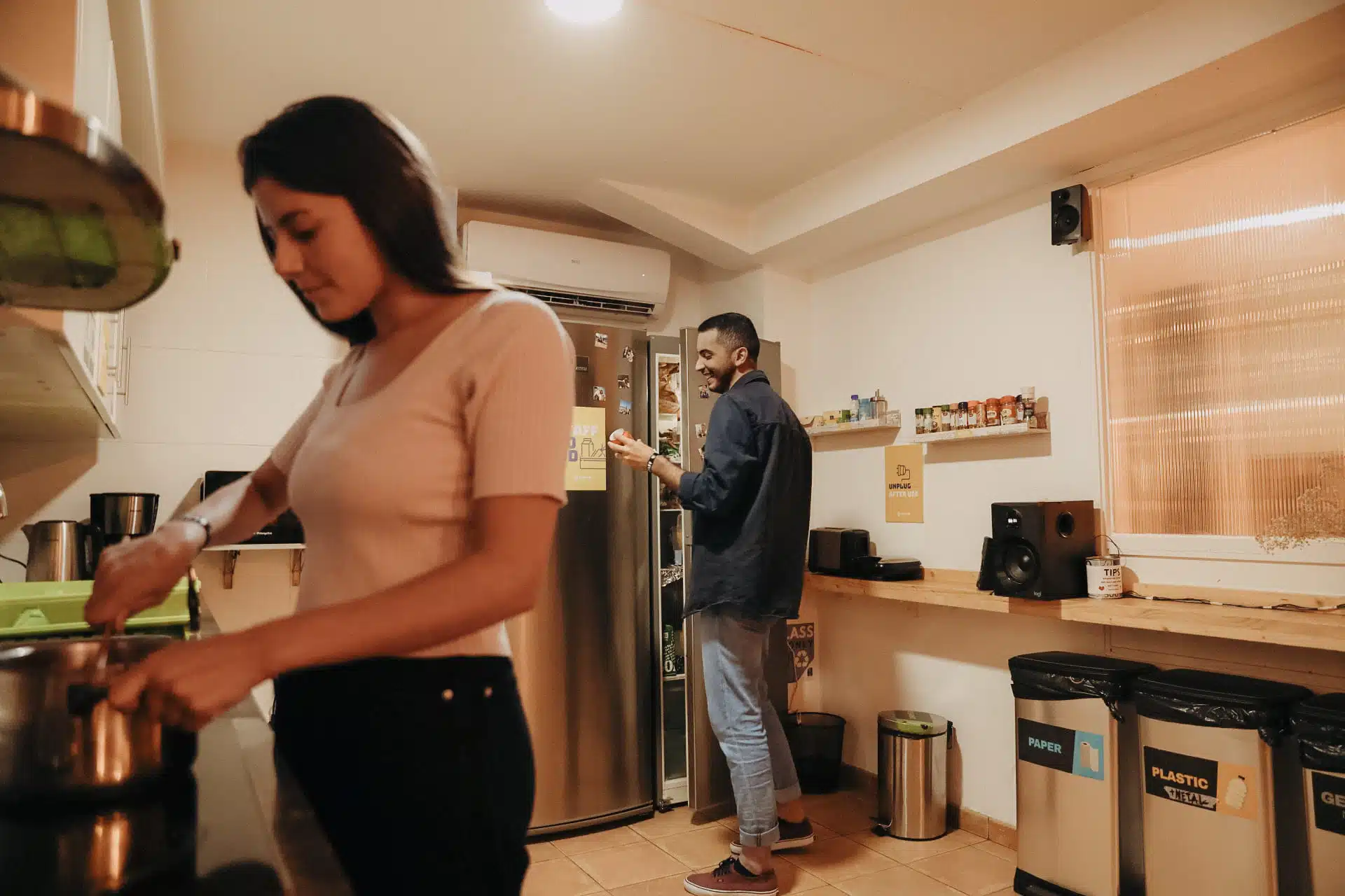 Group of solo travellers cooking in the kitchen at Batlló Onefam Hostel Barcelona